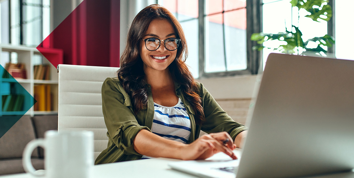 a woman is sitting at a desk using a laptop computer