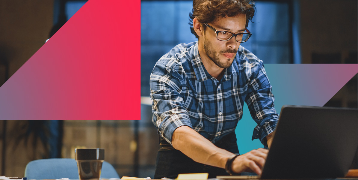 a man in a plaid shirt is using a laptop computer