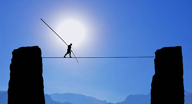 a man is walking on a tightrope with mountains in the background